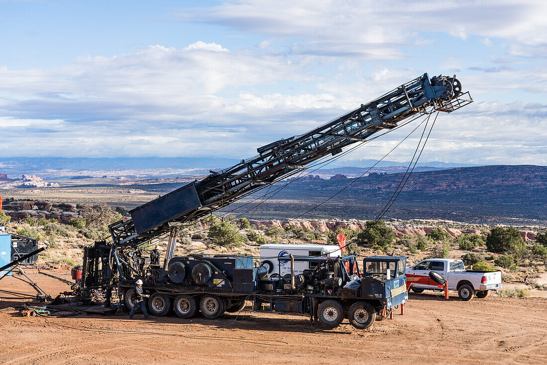 Telescoping truck-mounted workover rig folding down