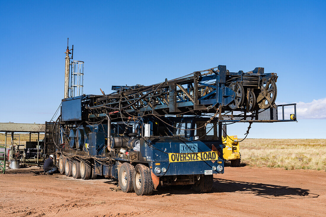 Telescoping truck-mounted workover rig folding down