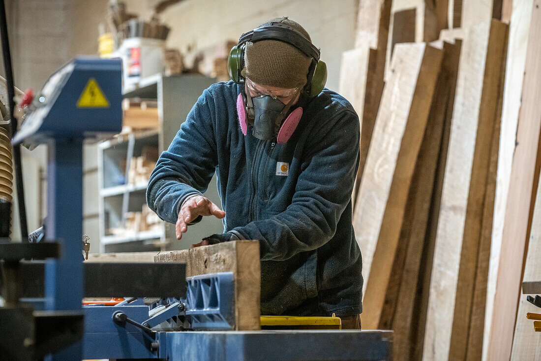 Man cutting pieces of lumber