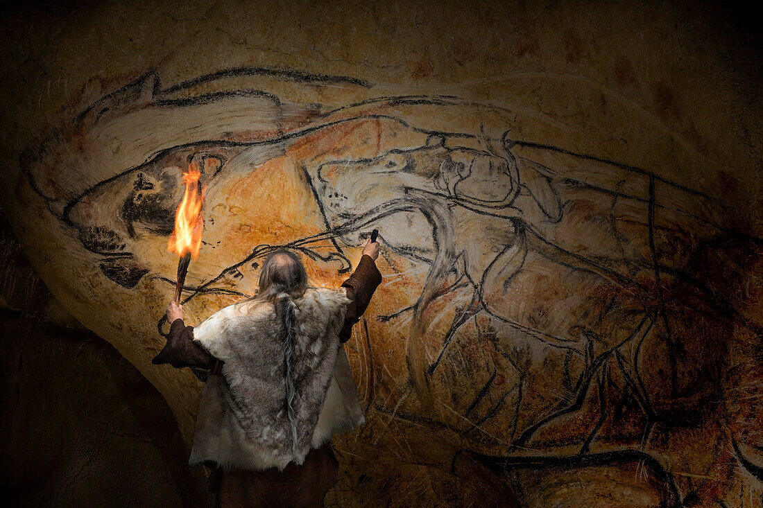 Artist drawing lions on wall, prehistoric reconstruction
