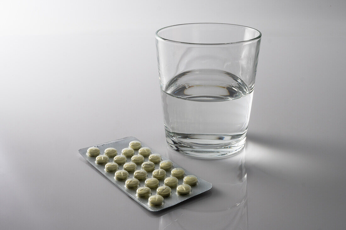 Pill blister pack along with a glass of water