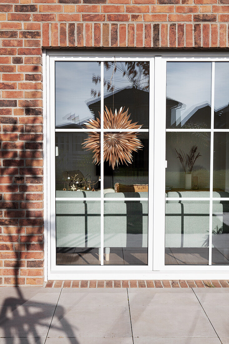 View from sunny terrace into a living room, with a star decoration on terrace door