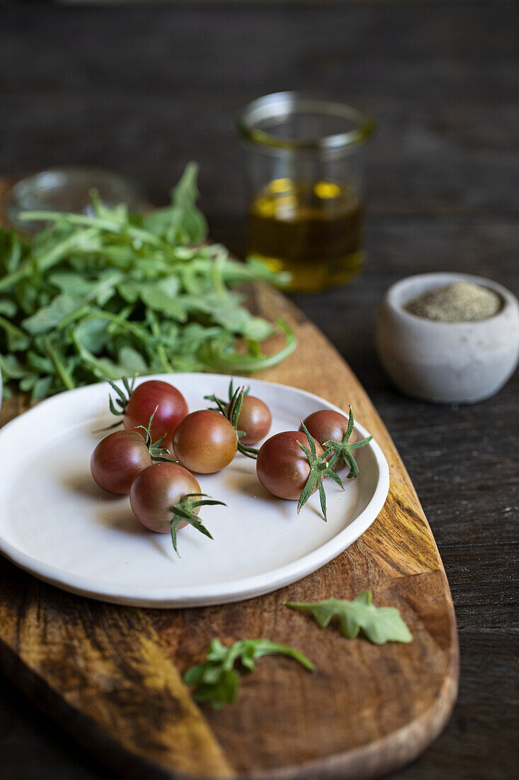 Kirschtomaten und Rucola auf Holzbrett