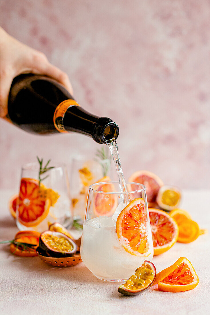 Makeing blood orange cocktails with prosecco and passion fruit