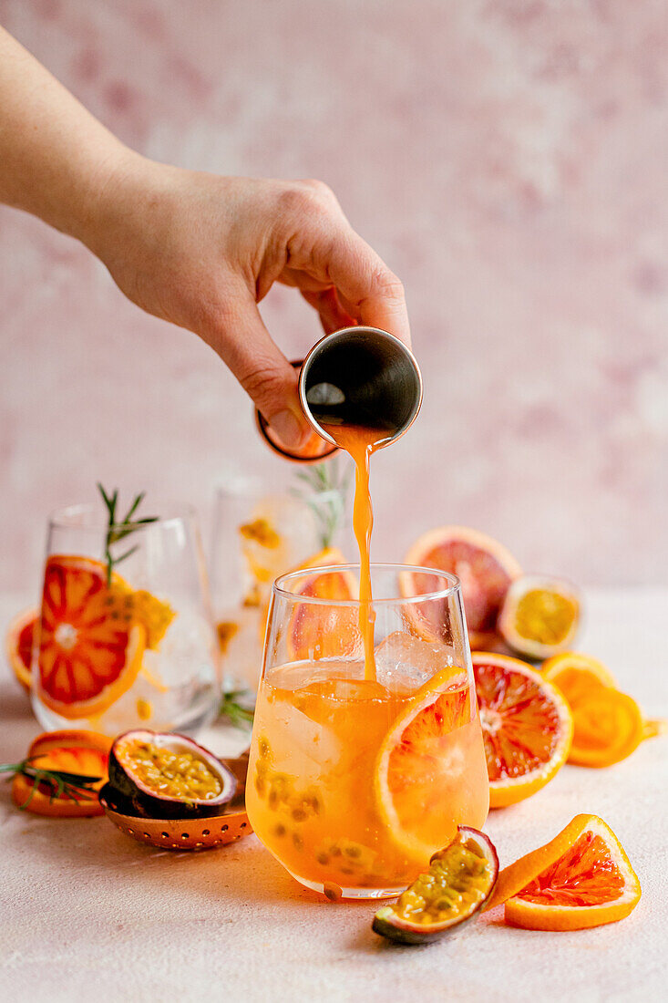 Preparing blood orange cocktail with prosecco and passion fruit