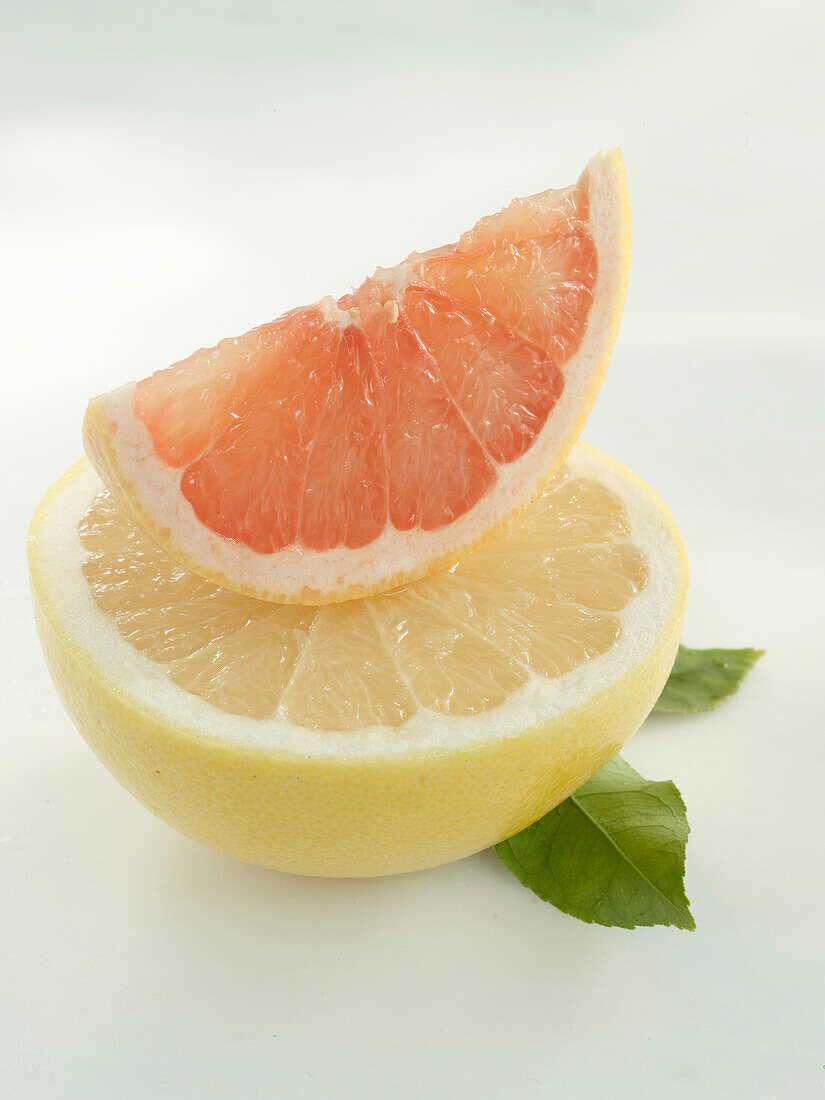 Grapefruit: gelbe Grapefruit-Hälfte und Pink Grapefruit- Schnitz