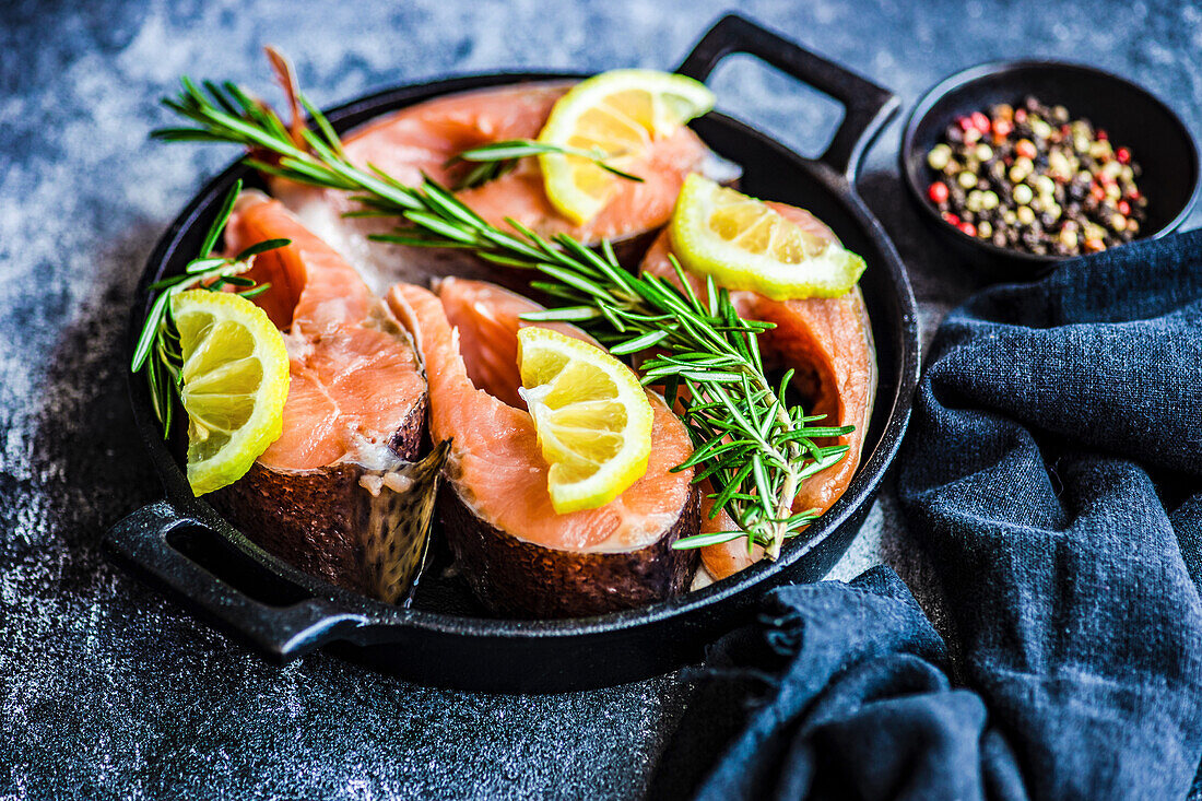 Healthy dinner cooking concept with trout steak with lemon and rosemary herb ready to cook