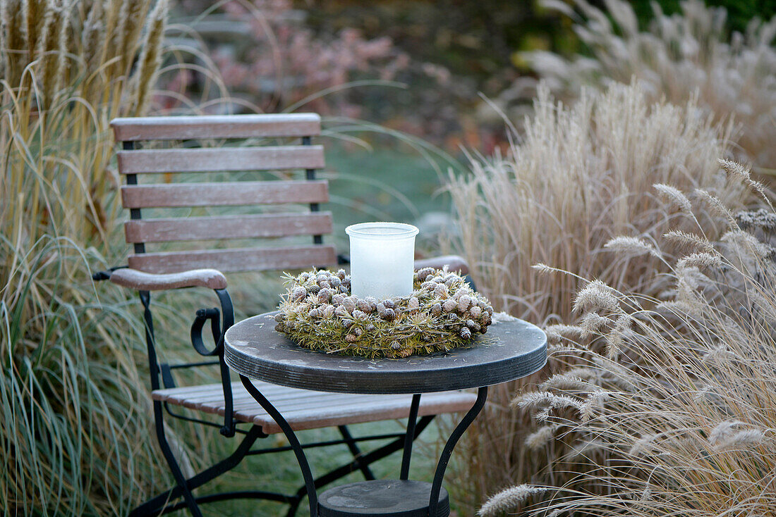 Wreath made of larch branches on a side table in the garden