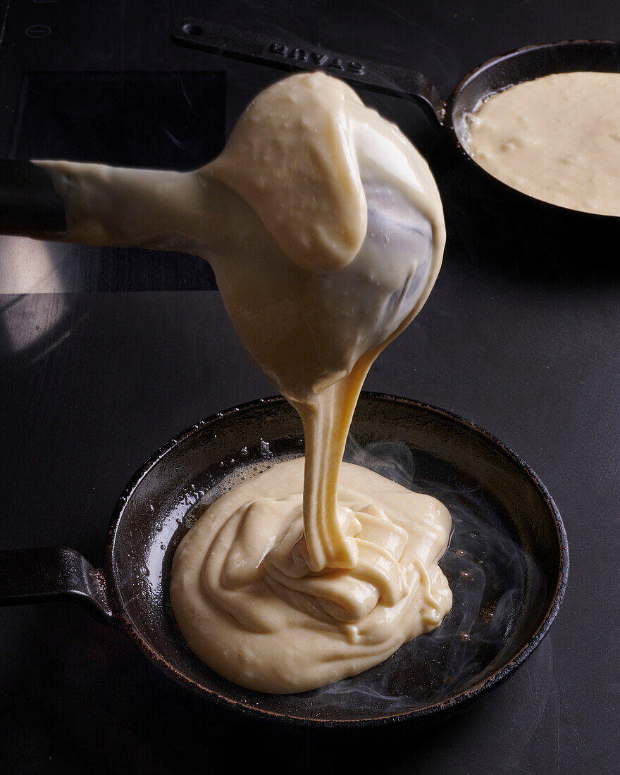 Making a blini in a pan Pour batter into pan with ladle