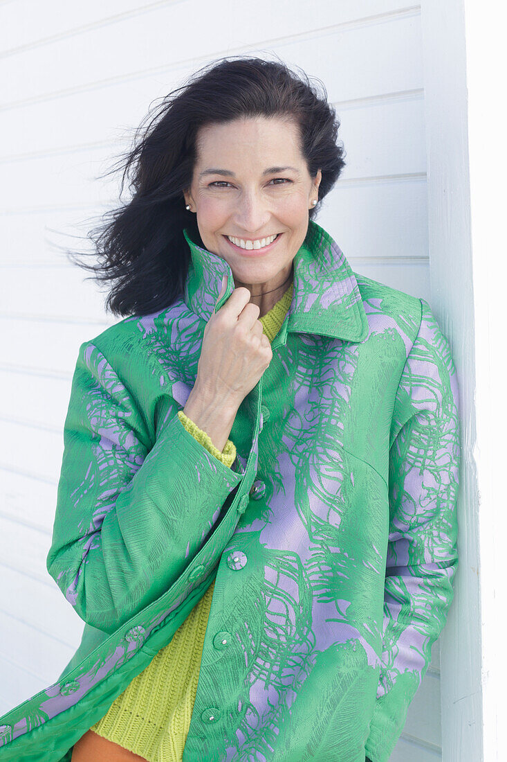 Mature, dark-haired woman in a green coat