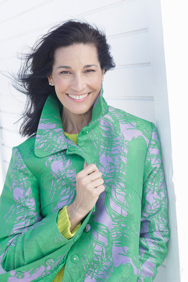 Mature, dark-haired woman in a green coat