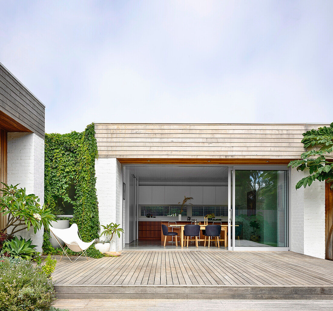 View of the terrace with a wooden deck and into kitchen with a dining area