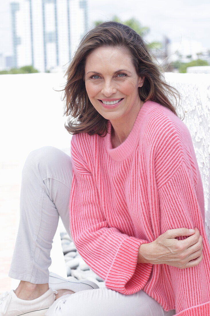 Woman in pink sweater and white pants