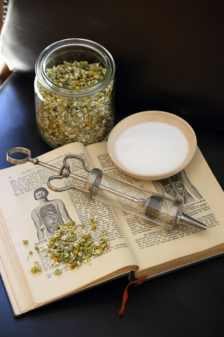 Tea herbs, old book and syringe