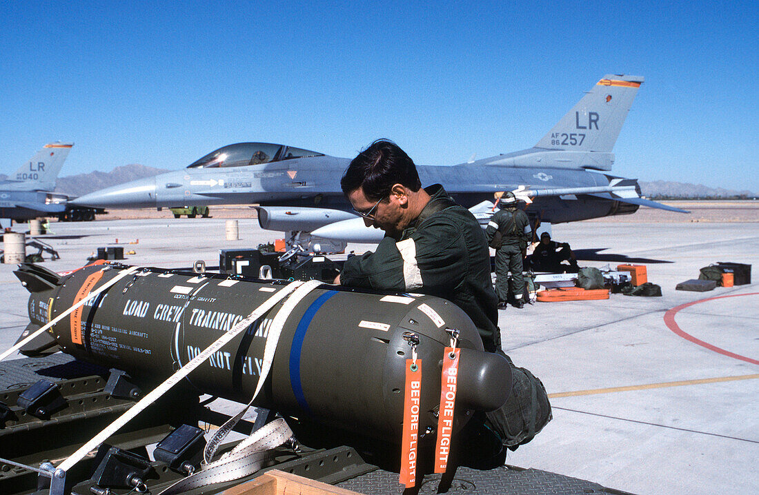 Staff sergeant securing cluster bomb on a munitions trailer