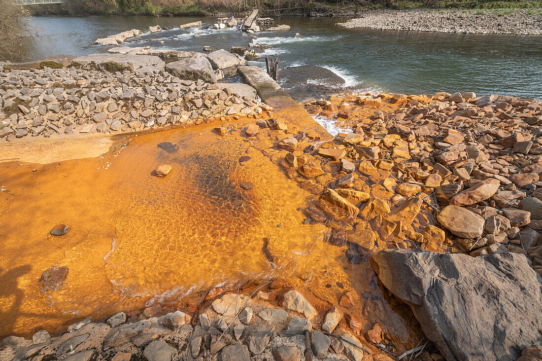 Orange iron oxide staining in stream, River Neath, Wales