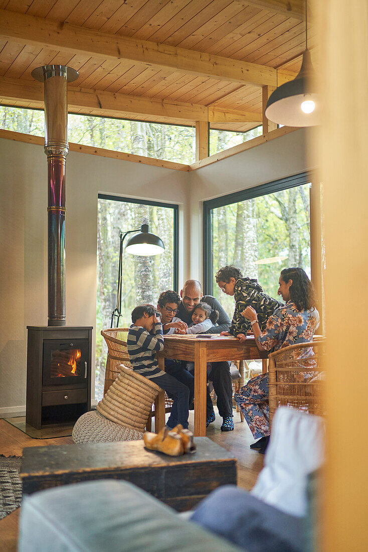Family playing game at cabin table by fireplace
