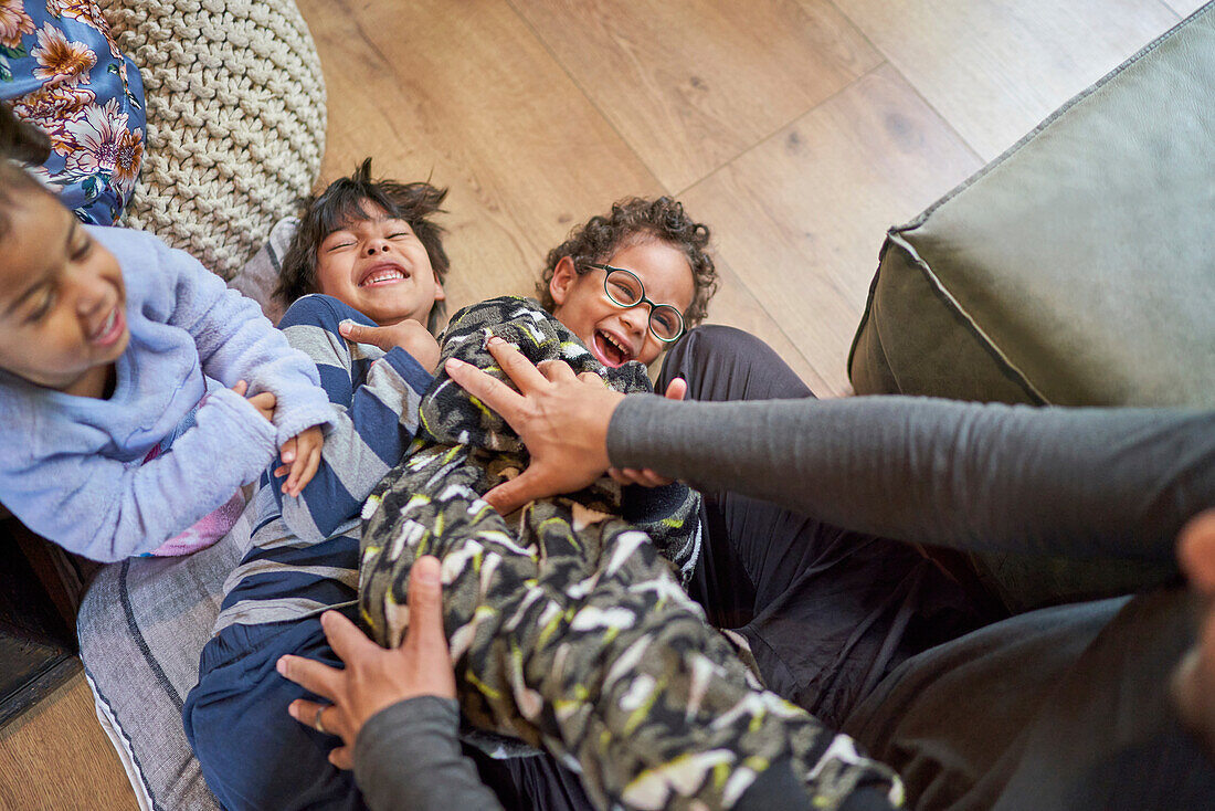 Playful father tickling kids