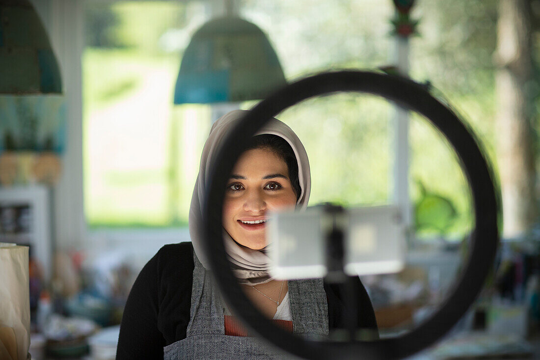 Female influencer in hijab recording in artist studio