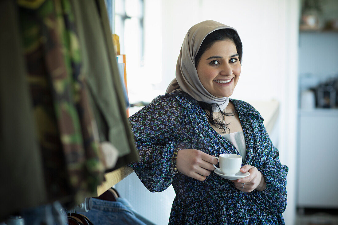Muslim woman in hijab drinking coffee