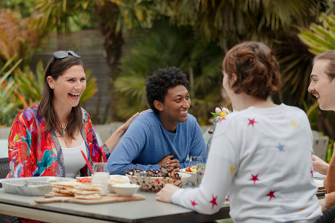 Happy friends enjoying lunch at patio table