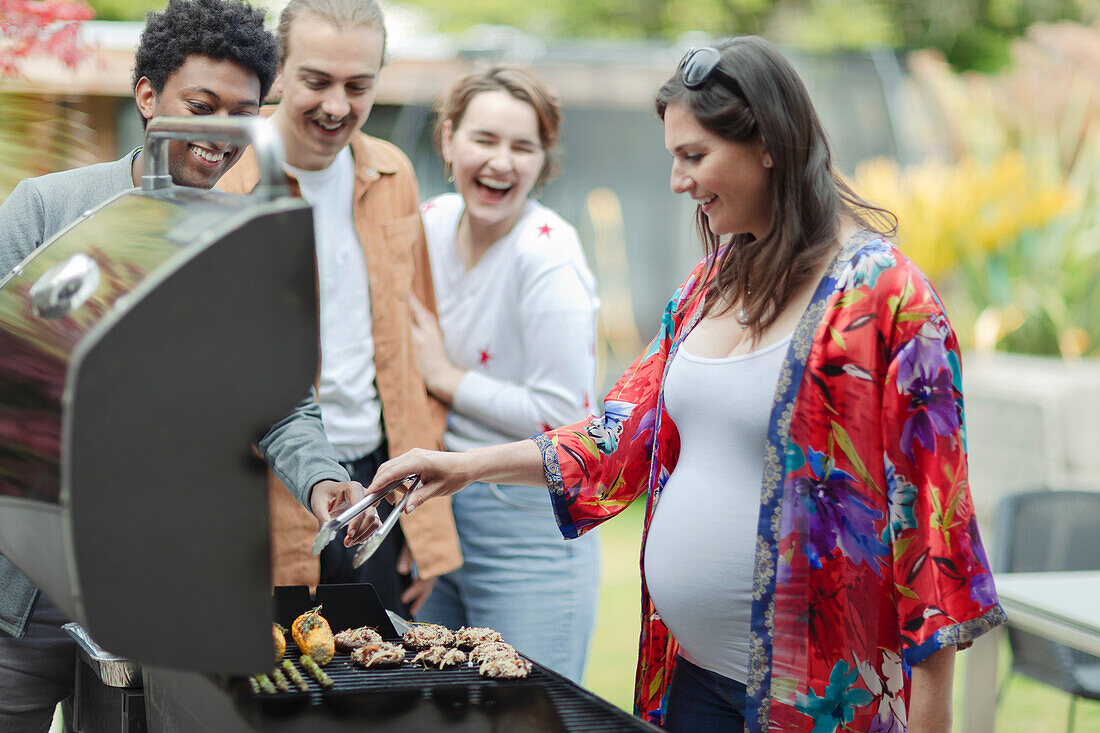 Friends barbecuing vegetables on patio