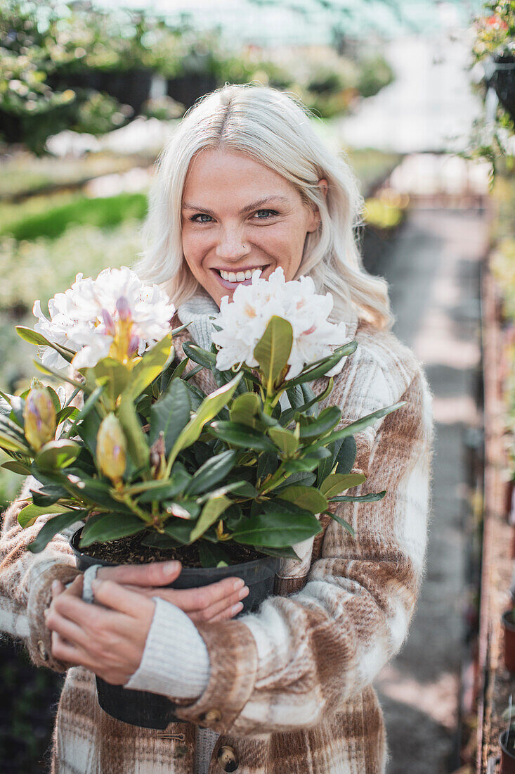 Happy woman holding potted flower