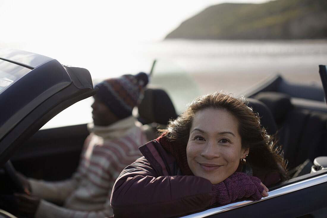 Happy woman in convertible on beach