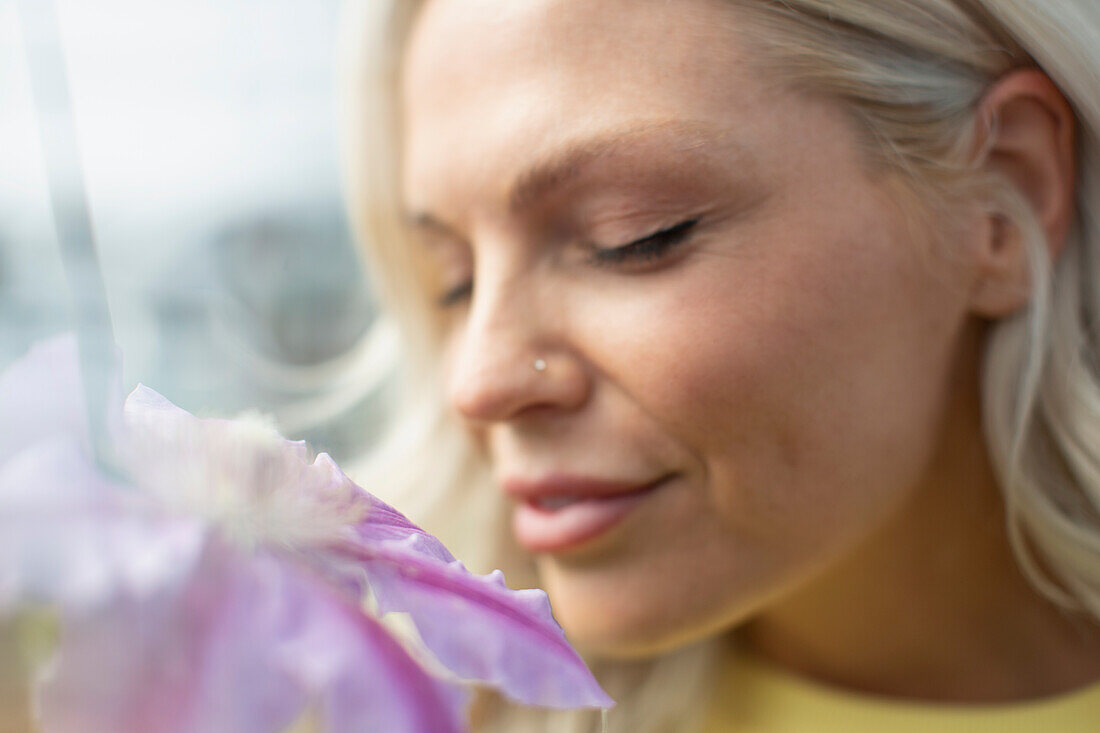 Close up woman smelling flower