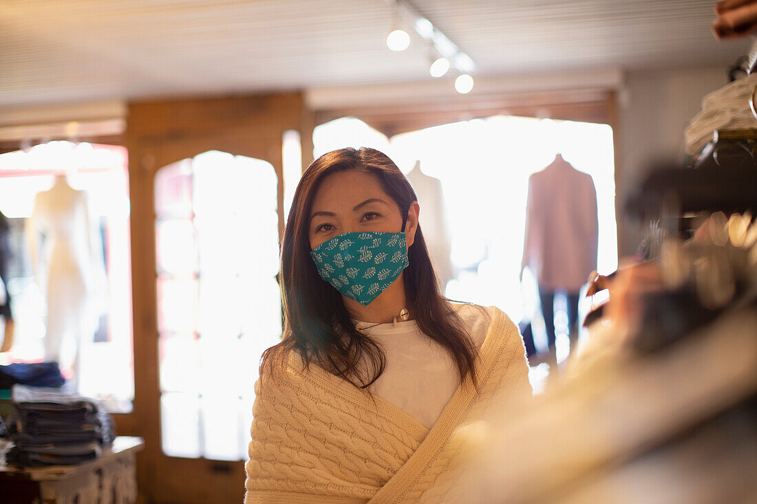Female shopper in face mask in clothing boutique