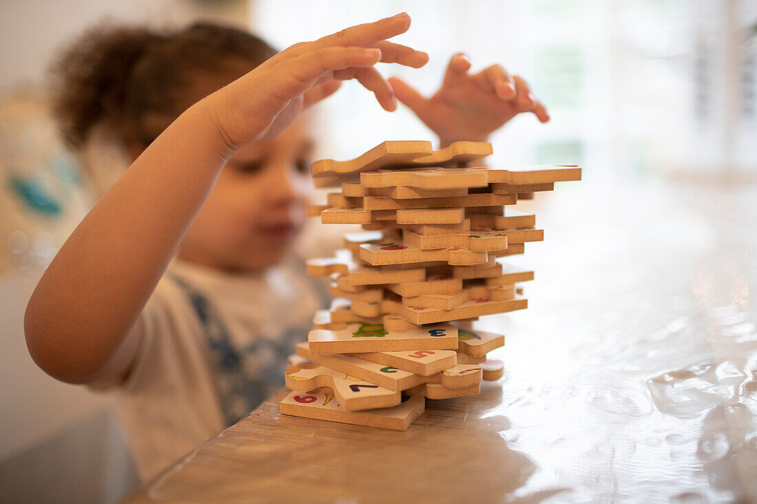 Girl stacking wood jigsaw pieces