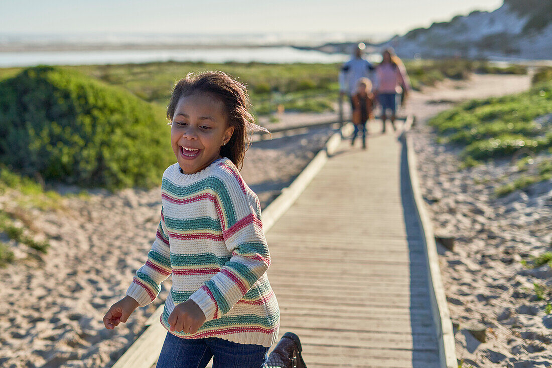 Happy girl running on beach boardwalk