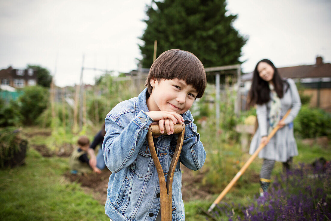 Smiling boy with shovel on allotment