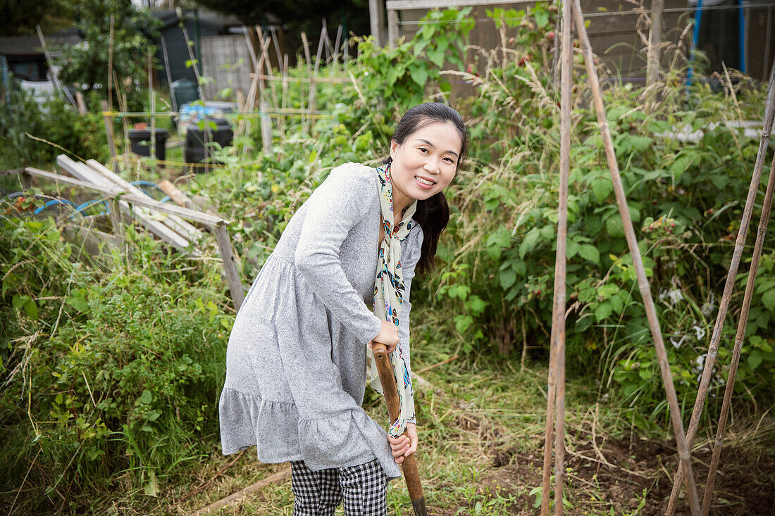 Happy woman gardening in vegetable garden