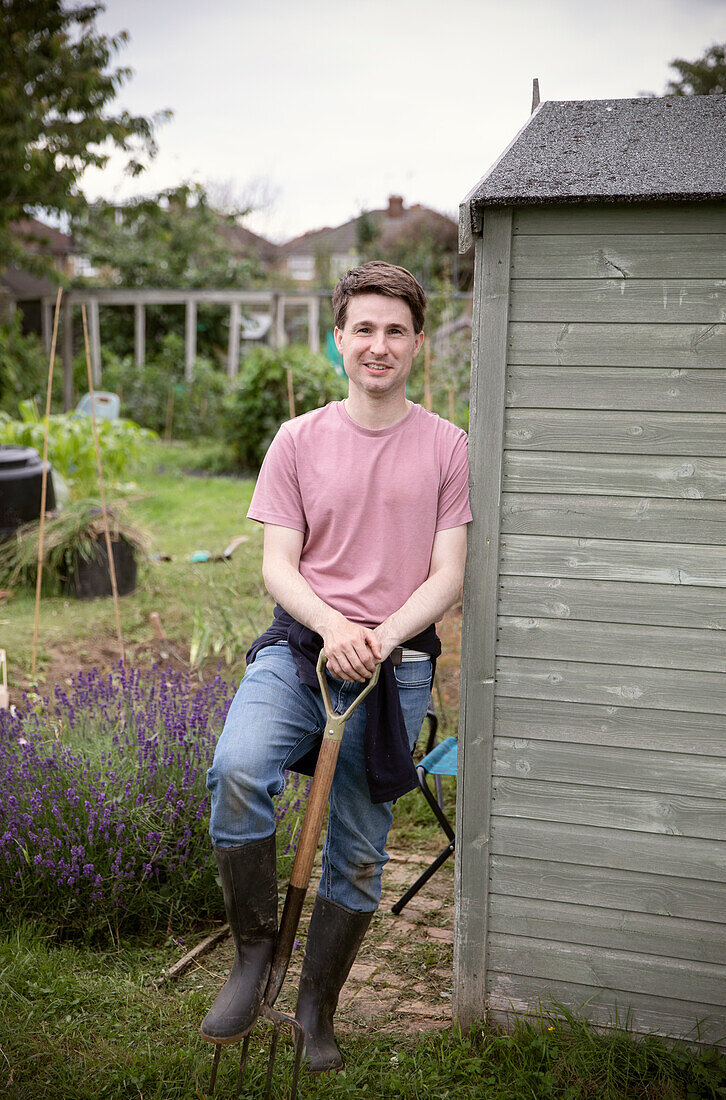 Happy man with pitchfork in garden