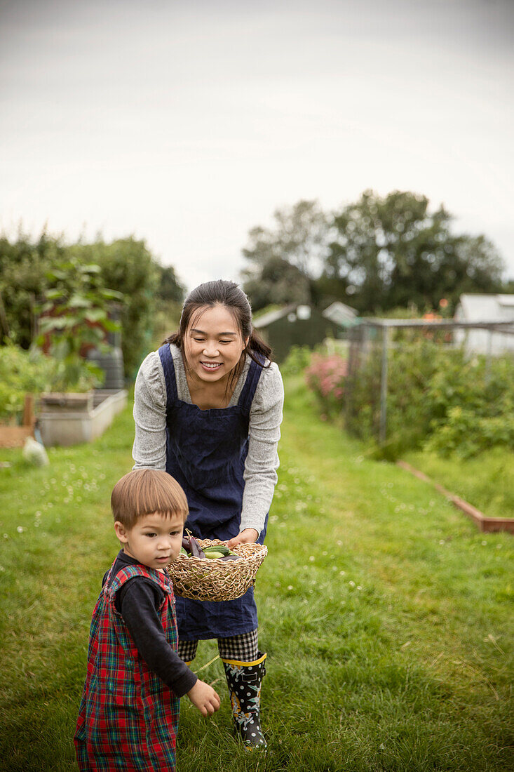 Smiling mother and toddler son in backyard garden