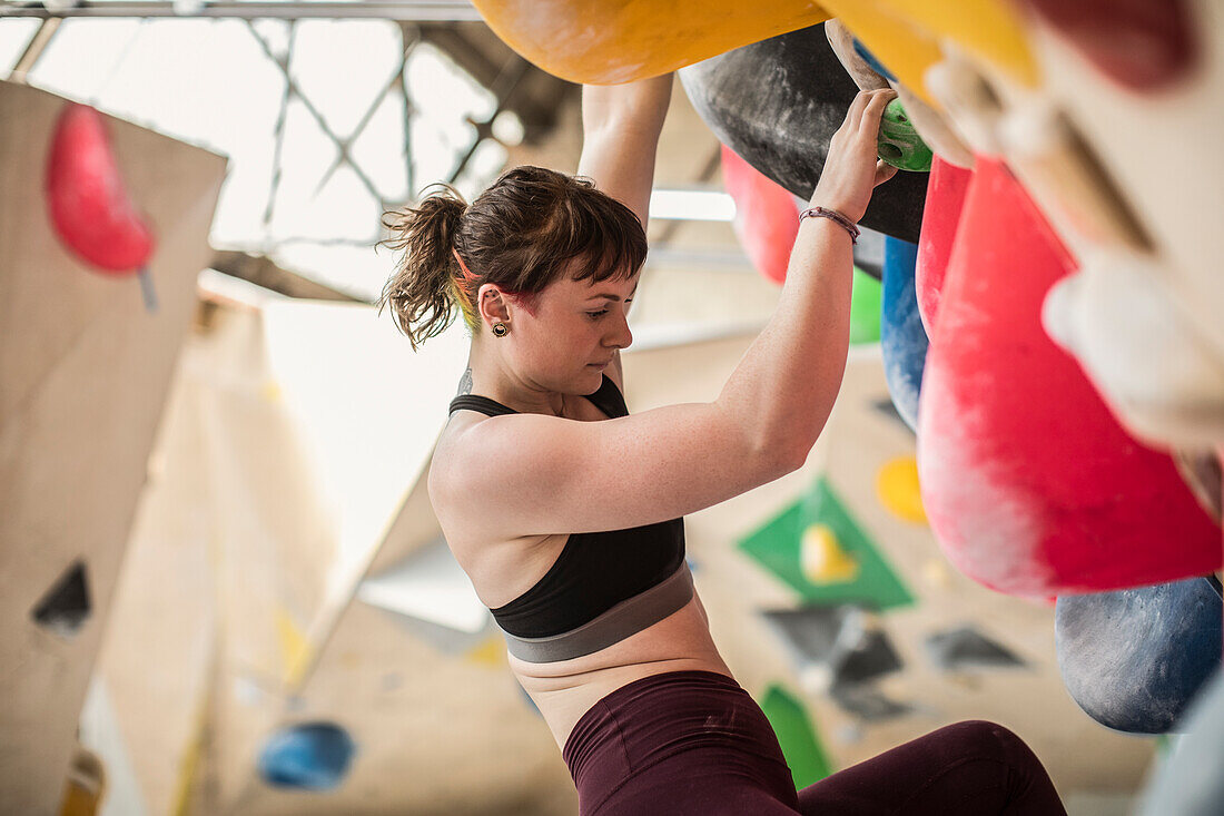 Young woman on rock climbing wall