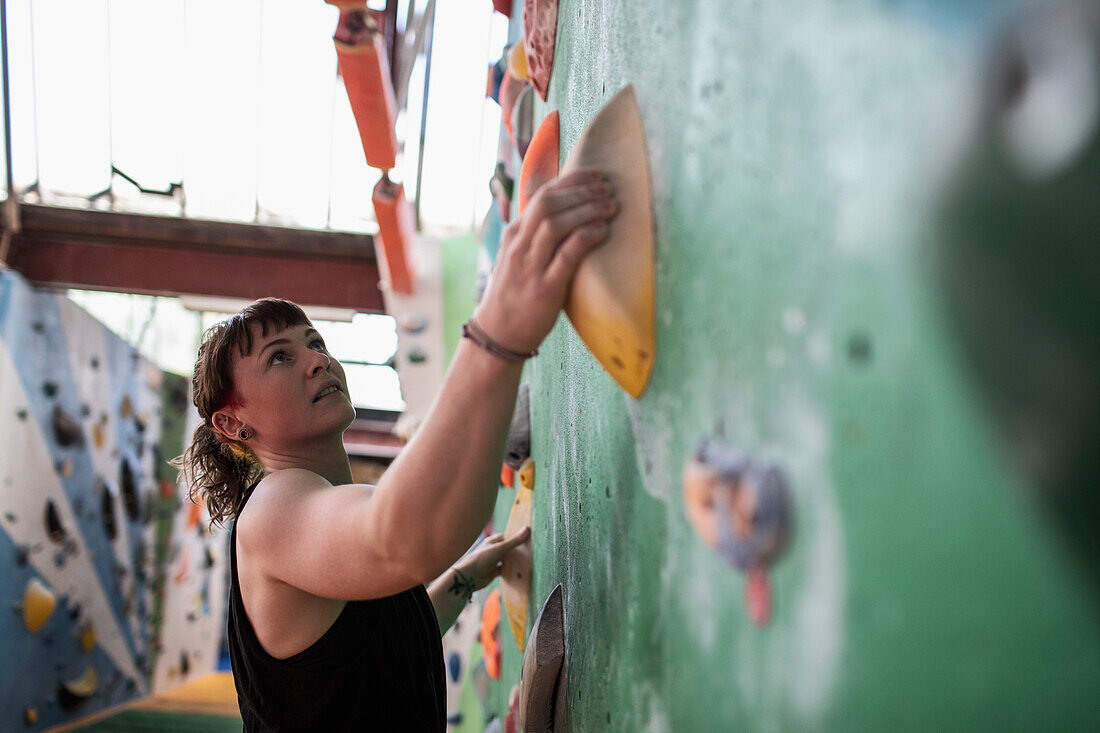 Young female rock climber on climbing wall