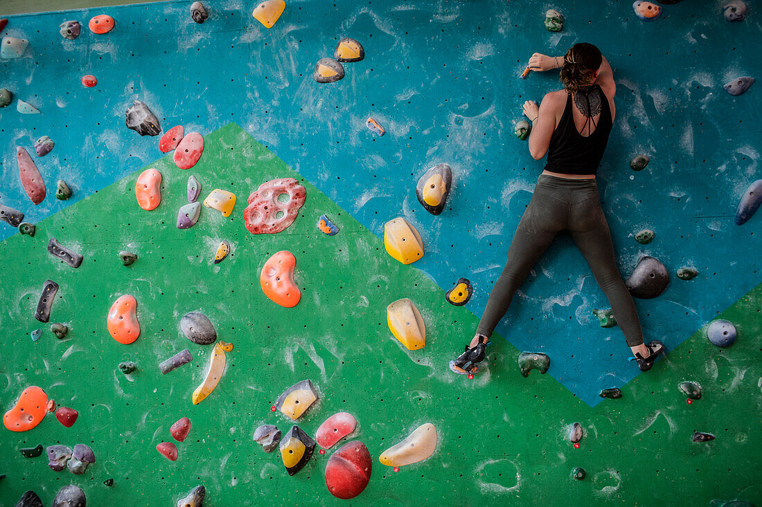 Female rock climber training on climbing wall