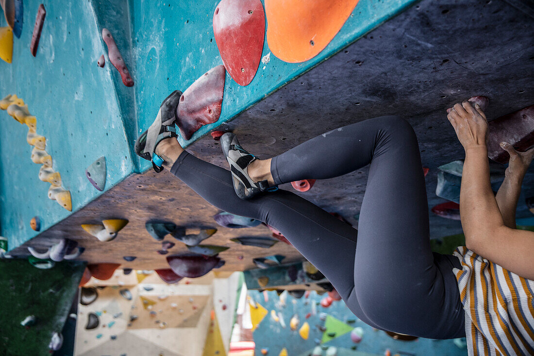 Legs of female rock climber on climbing wall