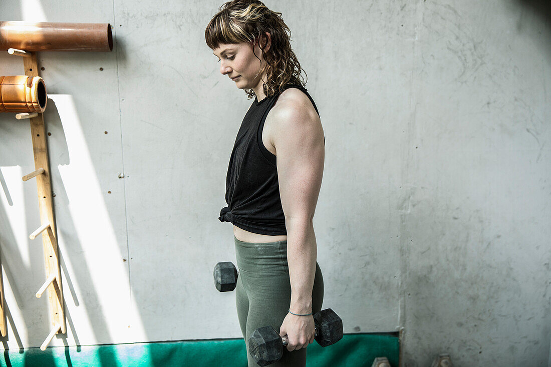 Young woman with dumbbells working out