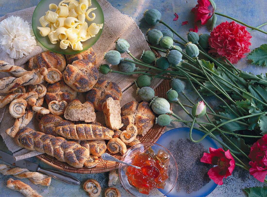 Still life with poppy blossoms, poppy pods and poppy pastries