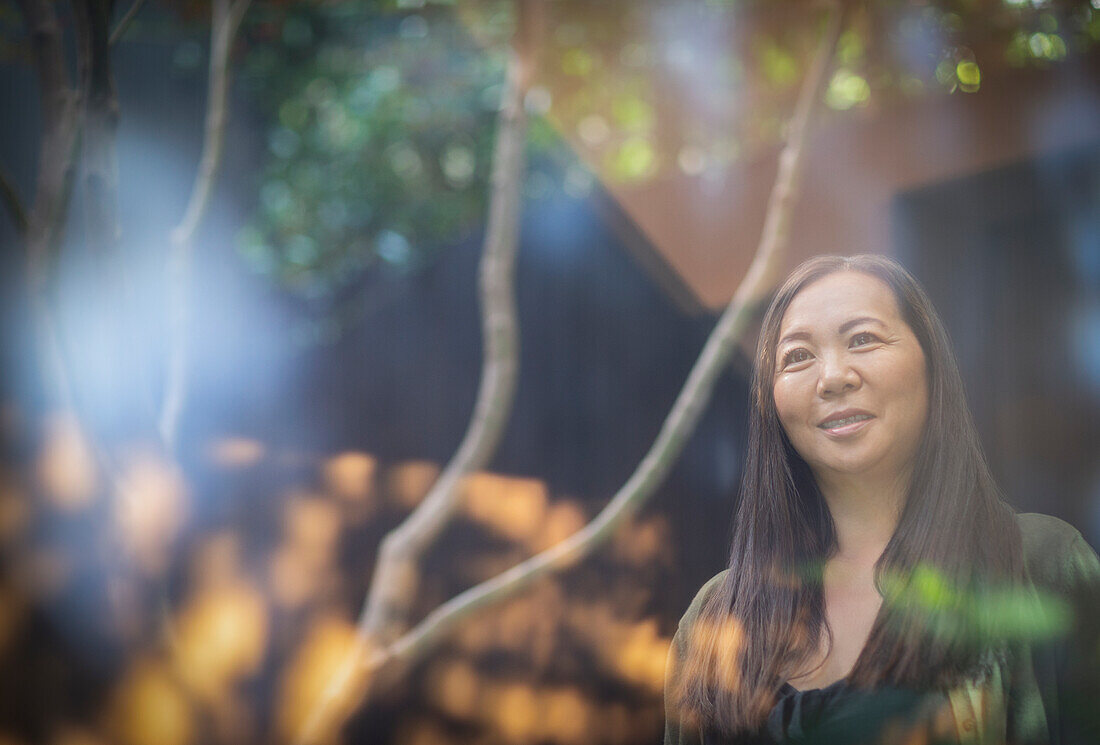 Smiling woman standing in sunny courtyard