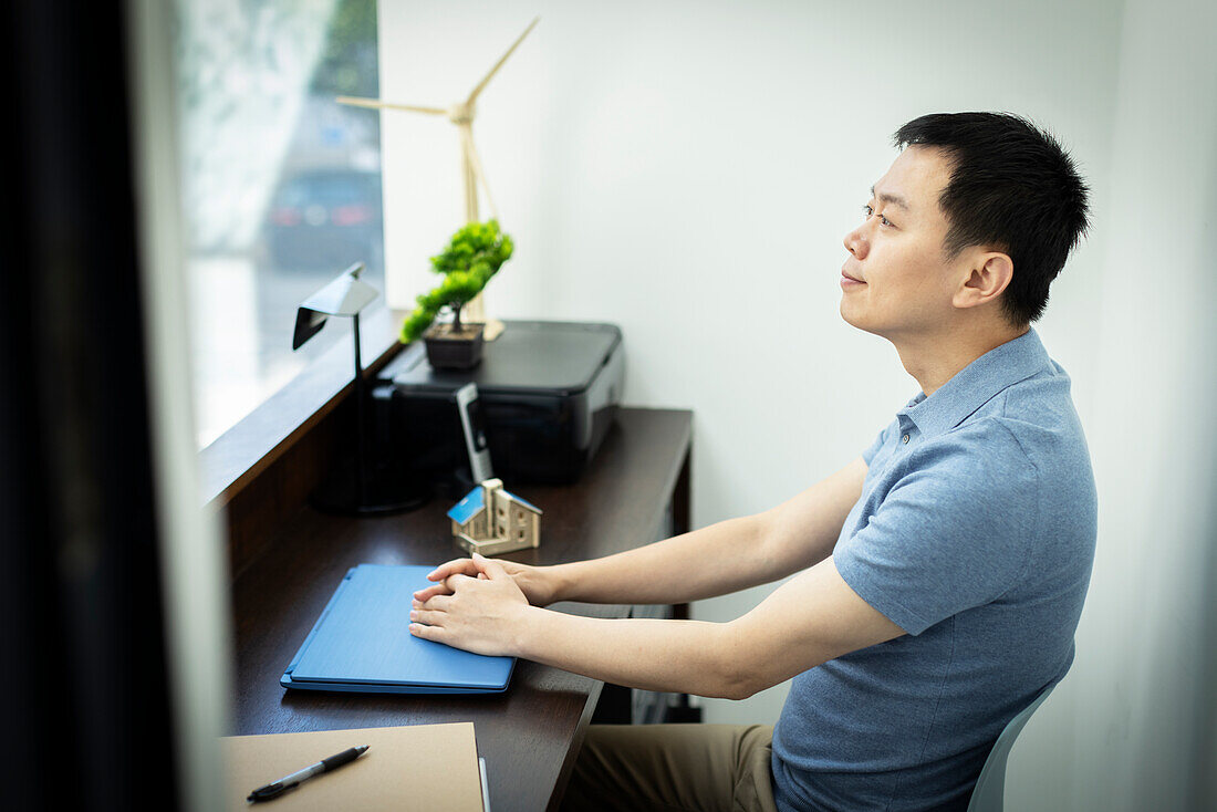 Happy male engineer sitting at desk in office