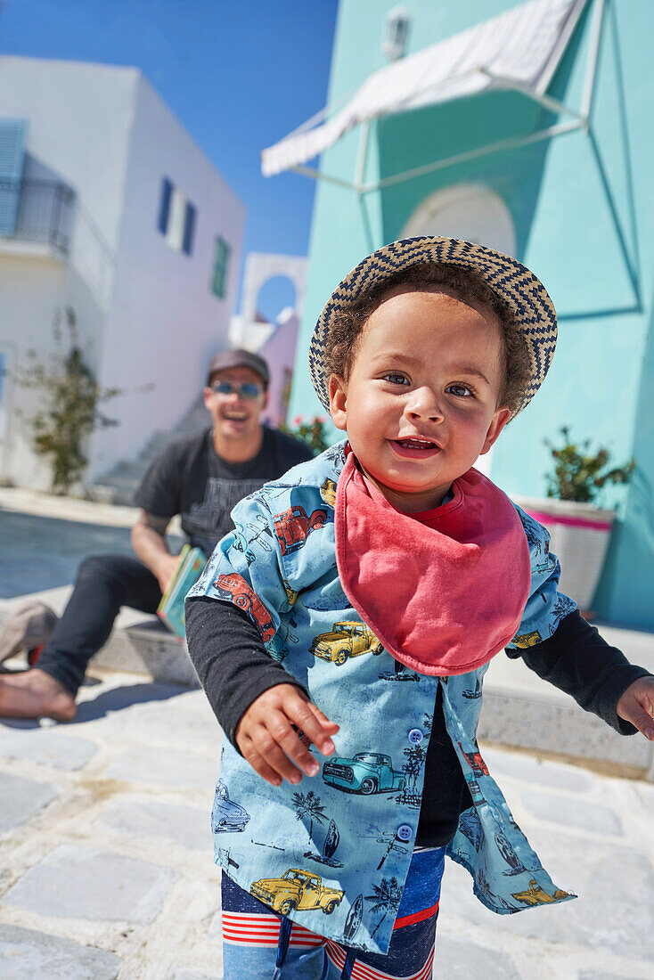Smiling toddler boy on sunny street