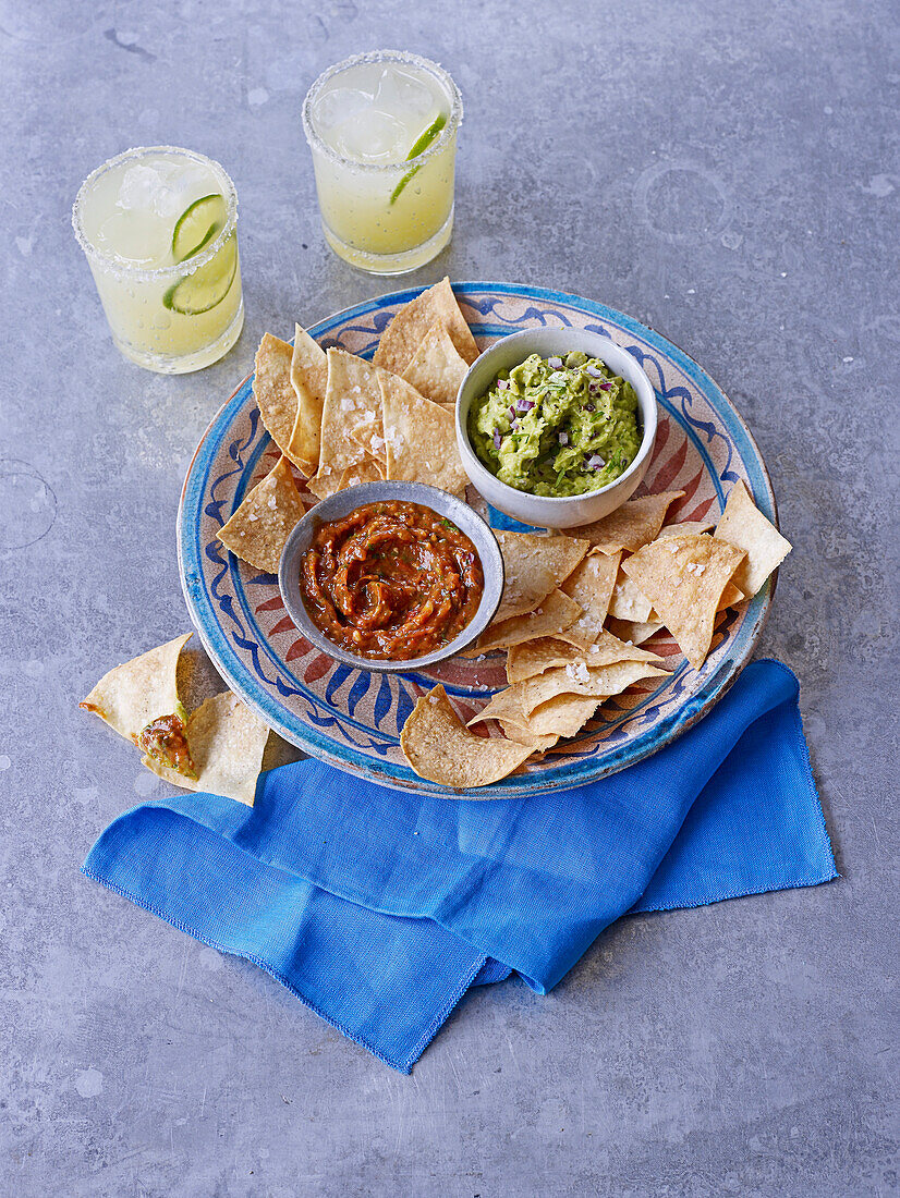 Hausgemachte Tortilla-Chips mit Guacamole und Salsa aus gegrillten Tomaten