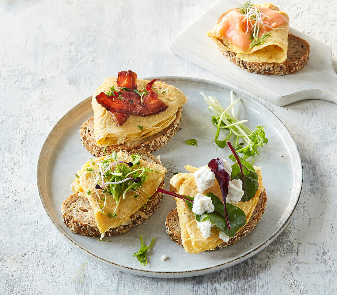 Bread with omelet, salmon and bacon strips