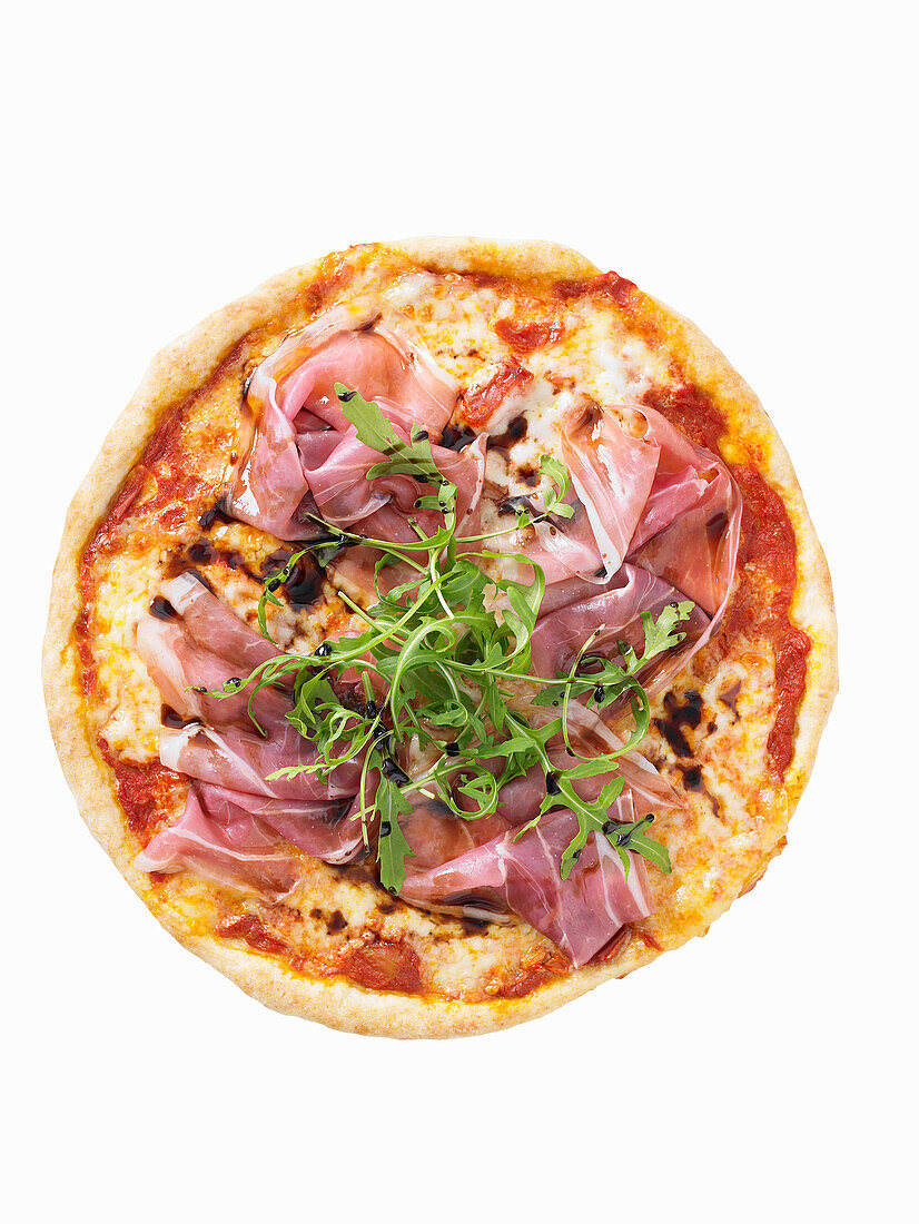 Pizza mit Schinken und Rucola vor weißem Hintergrund