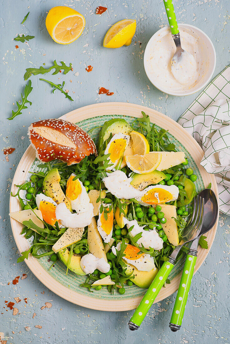 Rocket salad with green peas, avocado, eggs, cheese, and yogurt mayonnaise dressing