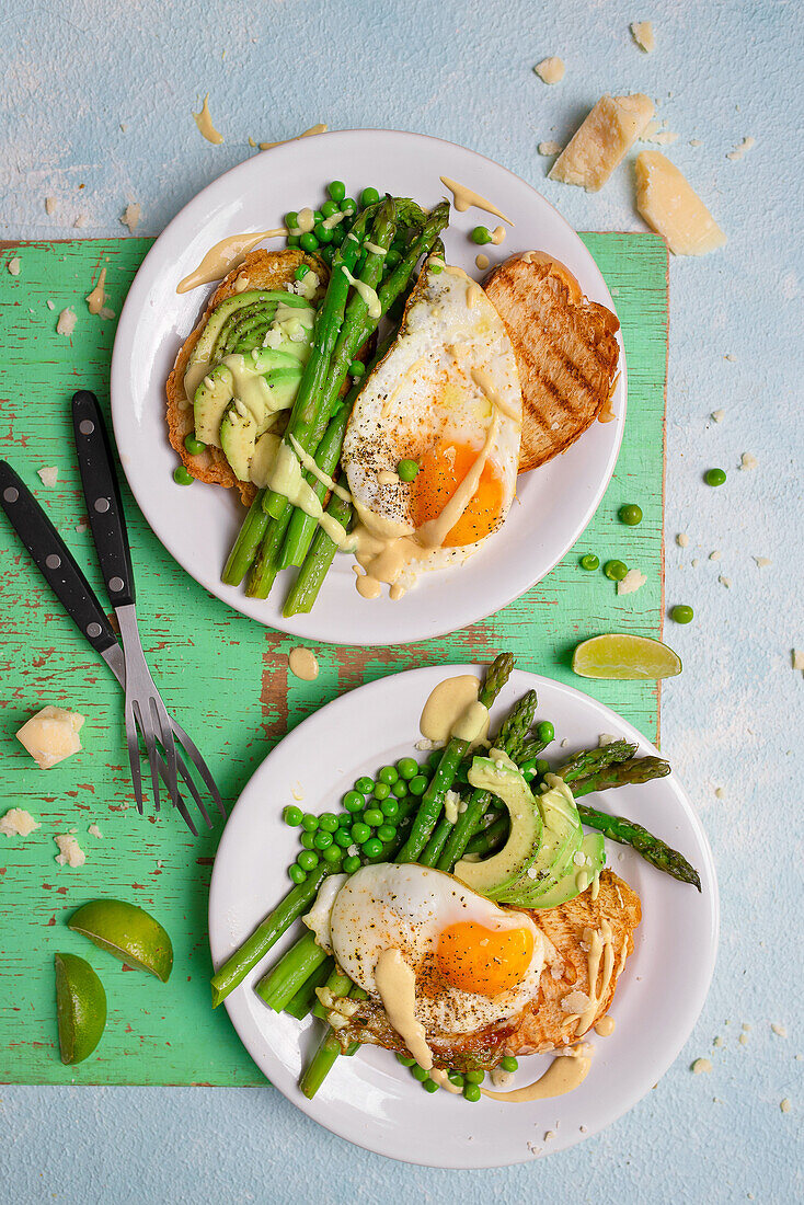 Toasted challah slices with fried egg, avocado, peas and hollandaise sauce